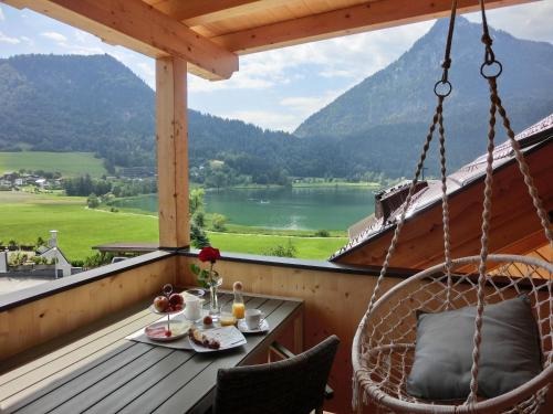 a balcony with a table and chairs and a view at Aparthotel Buchauer-Tirol in Thiersee