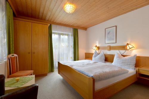 1 dormitorio con 1 cama grande y techo de madera en Appartement Gratt en Ellmau