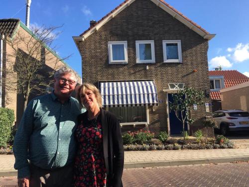 a man and a woman standing in front of a house at Cozy Bed and Breakfast in Elst