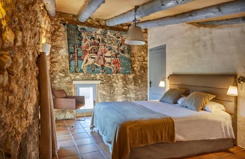 um quarto com uma cama grande numa parede de pedra em Casa Azul at Masia Nur Sitges, Adults only em Canyelles