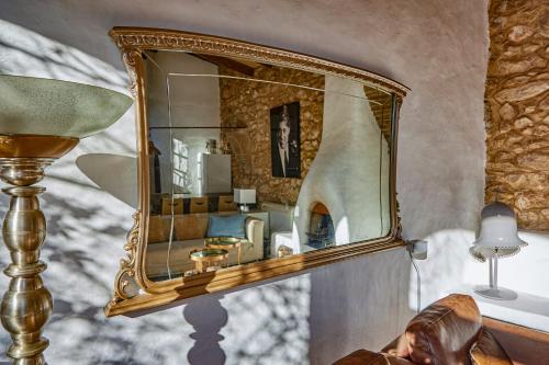 einen goldenen Spiegel an einer Wand in einem Zimmer in der Unterkunft Casa Azul at Masia Nur Sitges, Adults only in Canyelles