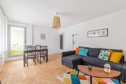 een woonkamer met een bank en een tafel bij Beautiful 1-bedroom w balcony and garden near Lyons city center Welkeys in Caluire-et-Cuire