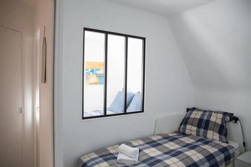 um quarto com uma cama e um espelho na parede em Duplex with terrace nearby the beach of Cabourg Welkeys em Cabourg