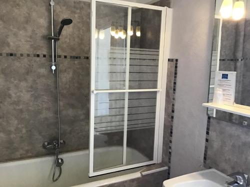 La salle de bains est pourvue d'une douche avec une porte en verre. dans l'établissement L'ilot Fleuri, au Lavandou