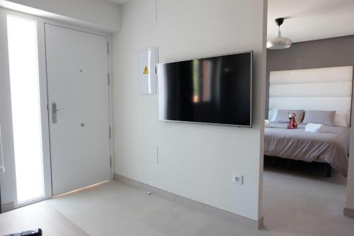 een woonkamer met een tv aan de muur bij Loft con piscina Adults Only in Chiclana de la Frontera