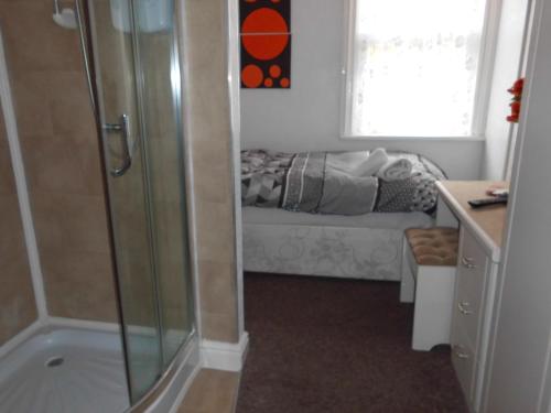 a bathroom with a shower and a couch in the window at Jasmine Guest House in Bridlington
