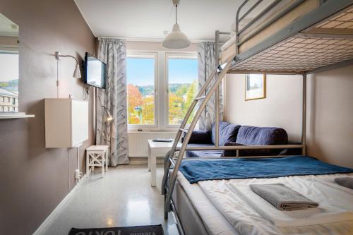 a bedroom with two bunk beds and a window at Hotel Sollefteå in Sollefteå