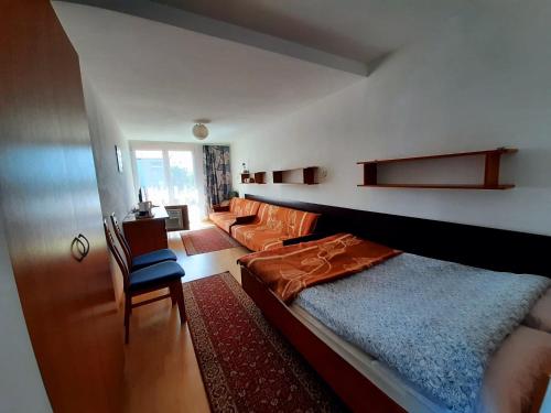 1 dormitorio pequeño con 1 cama y 1 silla en OW Żeglarz, en Jastrzębia Góra