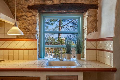 une cuisine avec un évier et une fenêtre dans l'établissement Casa La Premsa at Masia Nur Sitges, Adults only, à Canyelles