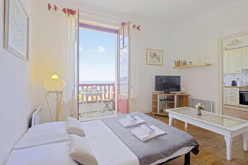昂代Appartement Mimosas - 3 étoiles - Welkeys的一间卧室，里面有一张床、一张桌子和一扇窗户