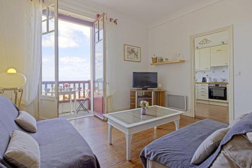 昂代Appartement Mimosas - 3 étoiles - Welkeys的带沙发和桌子的客厅
