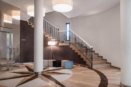 a lobby with a spiral staircase and a stair case at Hotel Parque Real in Ciudad Real