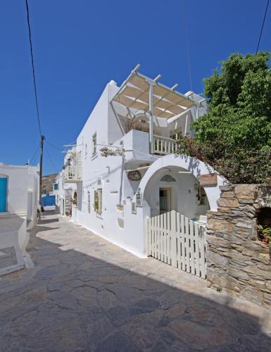 a white building with a gate and a fence at Villa Katapoliani I in Katapola