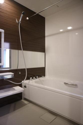 uma casa de banho com uma banheira branca e um chuveiro em Yoshiki Stay em Furukawachō