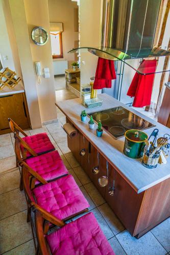 a kitchen with a counter with a sink and two chairs at Chariklia's House with private pool in Káto Lekhónia