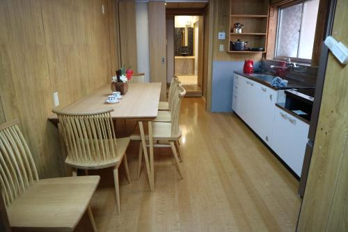 une cuisine avec une table et des chaises dans une pièce dans l'établissement Yoshiki Stay, à Furukawachō
