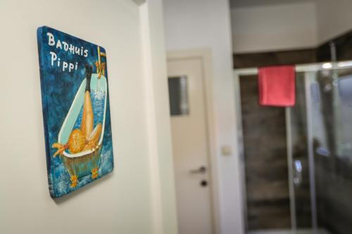 a picture of a book hanging on a wall at Villa Kakelbont Borgloon in Borgloon