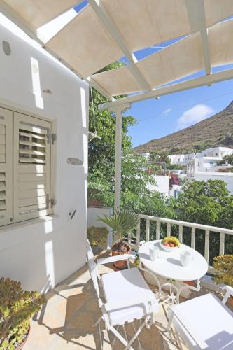 a patio with a table and chairs on a balcony at Villa Katapoliani I in Katapola