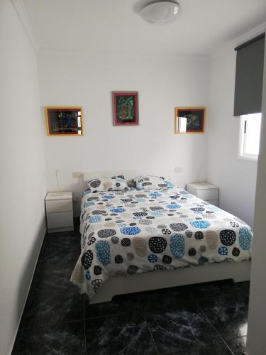 a bedroom with a bed with a blue and white comforter at Sun and Sea House 3 Rooms & Wifi in Arinaga