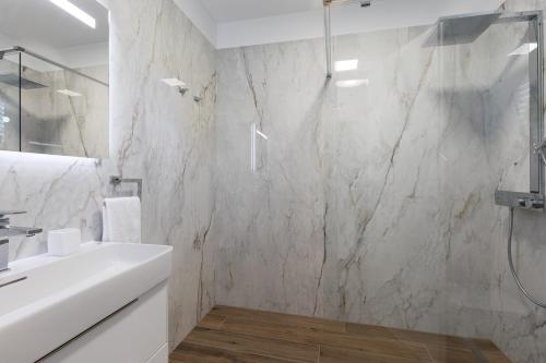 a bathroom with a white sink and a shower at Villa Aurora in Baška