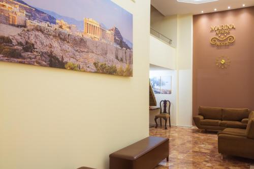 een wachtkamer met een bank en een schilderij aan de muur bij Hotel Marina in Athene