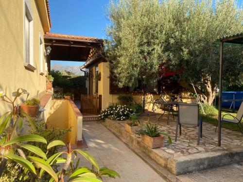 Cette maison dispose d'une terrasse avec une table et un arbre. dans l'établissement A casa di Eugenio, à Carini