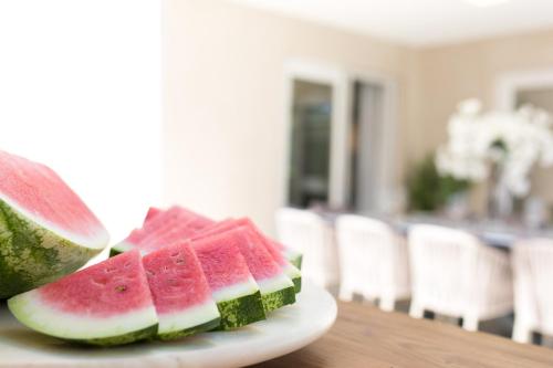 a plate with three slices of watermelon on a table at Villa Aurora in Baška