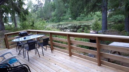 a wooden deck with a table and chairs on it at Granheim Hytte med 2 soverom in Birkeland