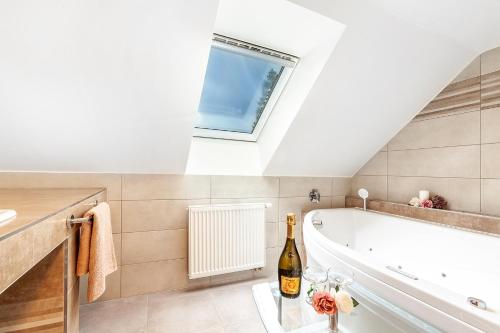 a bathroom with a white tub and a window at Penzion Bačalský mlýn in Morašice