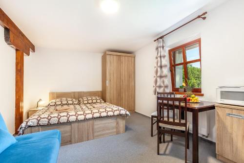 a bedroom with a bed and a table and a window at Penzion Bačalský mlýn in Morašice