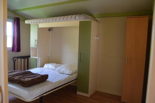 a bed in a room with a bunk bed at Camping La Charderie in Pont-de-Labeaume