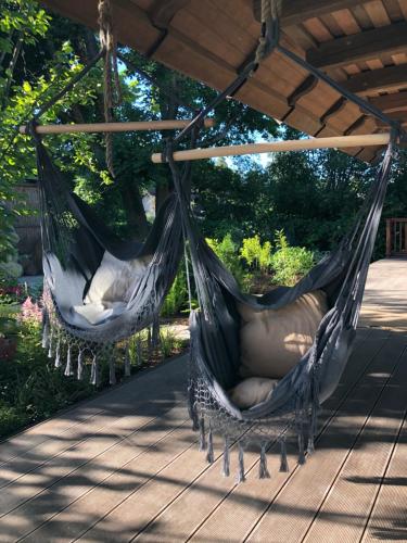 two hammocks hanging from a pergola on a patio at Villa Gaida in Saulkrasti