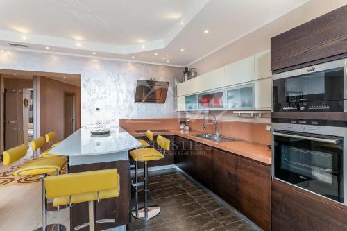 eine Küche mit einer Theke und gelben Barhockern in der Unterkunft Апартаменты с видом на Казино Монтекарло и море in Beausoleil