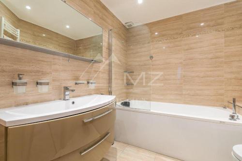 a bathroom with a bath tub and a sink and a bath tub at Апартаменты с видом на Казино Монтекарло и море in Beausoleil