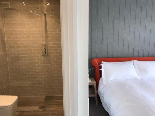 Schlafzimmer mit einem Bett und einer Glasdusche in der Unterkunft The Loft, Flat 3 in Bath