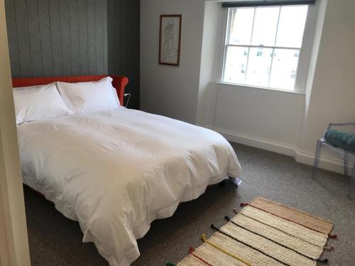 1 dormitorio con cama blanca y ventana en The Loft, Flat 3, en Bath