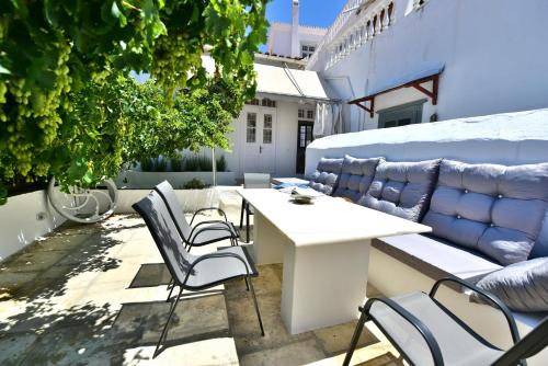 a patio with a white table and chairs at Hydra Art Suites in Hydra