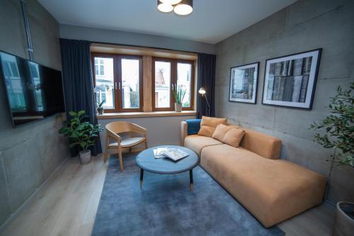 a living room with a couch and a table at Home Again Apartments Kirkegata in Stavanger