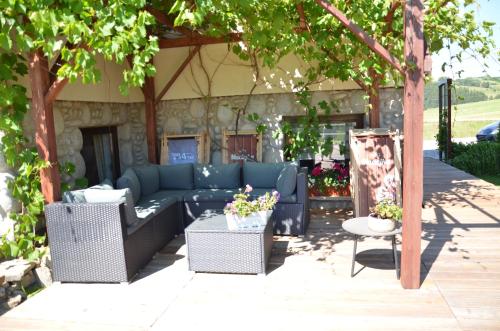 a patio with a couch and chairs and a table at Willa Maciejka in Trybsz