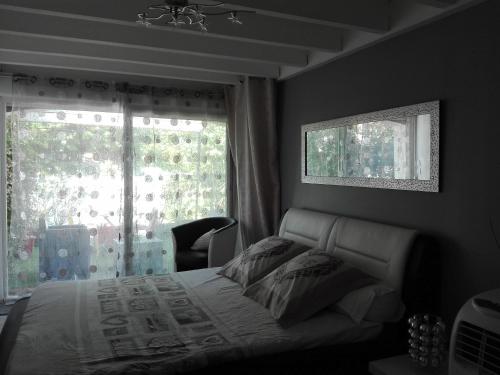 ein Schlafzimmer mit einem Bett und einem großen Fenster in der Unterkunft Studio Zure Ondoan - SPA et piscine chauffée in Tarnos