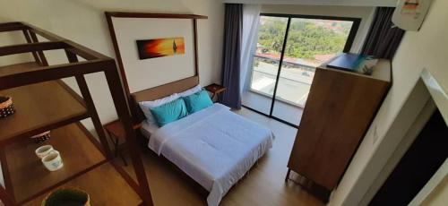 a small bedroom with a bed and a window at NRA @TimurBay Seafront Residence in Kuantan