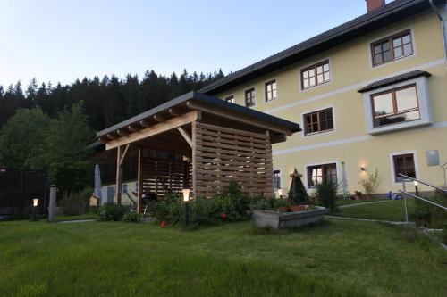 a large house with a porch and a grass yard at Biohof Teufel in Lunz am See