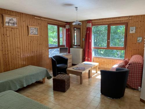 a living room with a bed and a desk with a computer at Apartements Le Bourg du Jean in Morzine