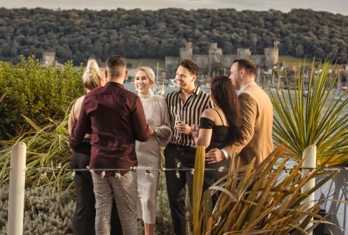 a group of people standing next to a fence at The Quay Hotel and Spa in Conwy
