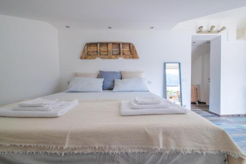 Un dormitorio con una cama grande con dos toallas encima. en Max Apartment, en Bellagio