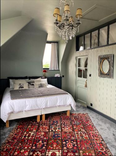 une chambre avec un grand lit et un tapis dans l'établissement La maison du grand rocher, à Ploubazlanec