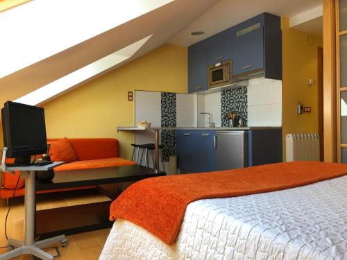 Un dormitorio con una cama y un escritorio con una computadora. en Apartamentos Albariño, en Vegadeo