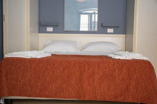 a bed with two white pillows and a red blanket at Le Plejadi in Castellammare del Golfo