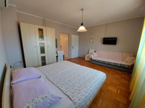 a bedroom with two beds and a couch at Kuća Luce in Mali Lošinj