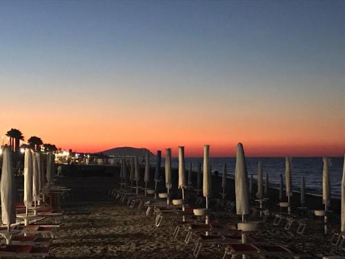 a row of umbrellas and chairs on a beach at Regina di Cuori Rooms in SantʼElpidio a Mare
